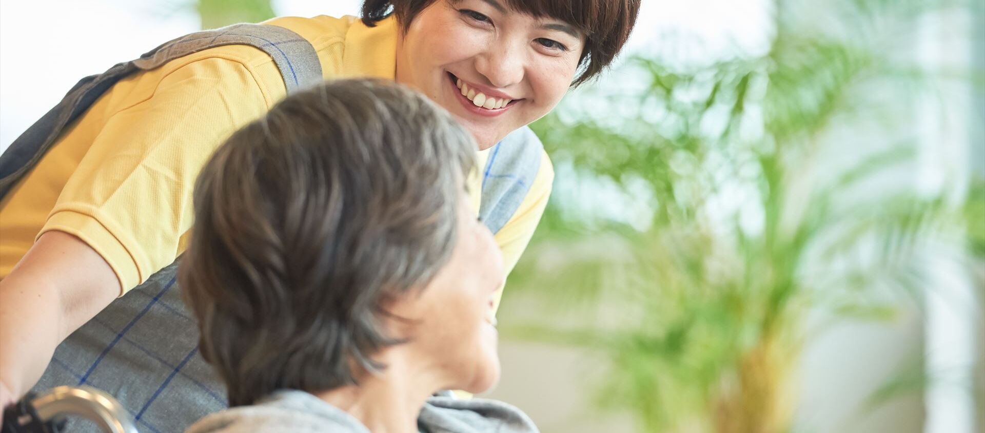 車いすの女性に声をかける女性ヘルパー